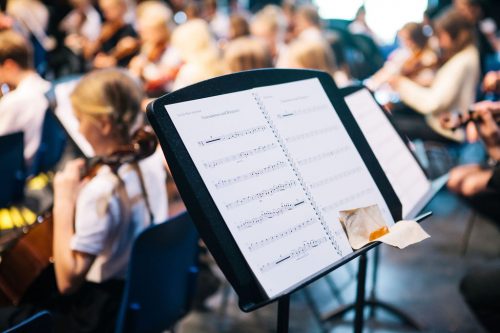 Sheet music on music stand at orchestral workshop event