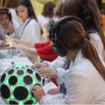 A group of young people wearing headphones interact with sensory toys