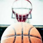 Close-up of a basketball aimed at a hoop.
