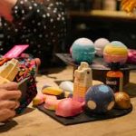 Colorful bath bombs and skincare products on a table.